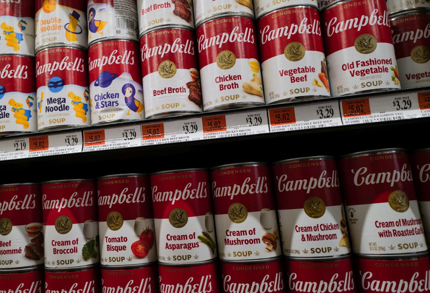 NEW YORK, NEW YORK - AUGUST 07: Cans of Campbell soup are displayed along a grocery store's shelves...